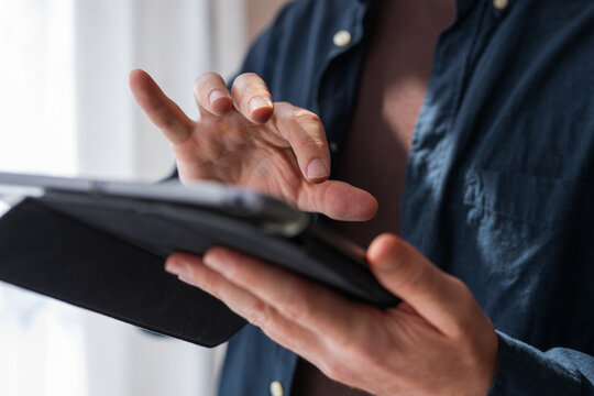 Hand gesture interacting with a tablet screen in a folio case for touch control, interface testing and app tutorial background for ux designers