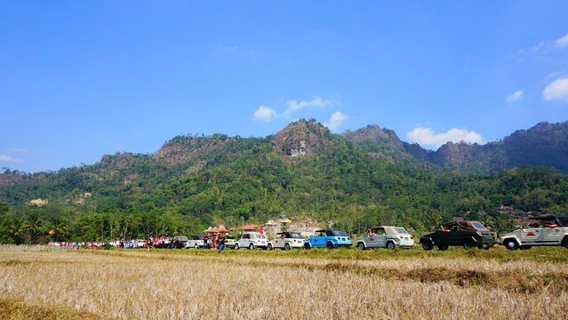 Scenic rural village and mountain landscape under a clear blue sky.