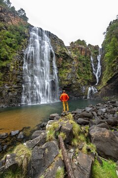 Young man standing in front of a waterfall, Lisbon Falls, long exposure, near Graskop, Mpumalanga, South Africa
