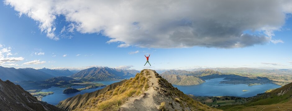 Hiker takes a skydive, views of mountains and lake from Mount Roy, Roys Peak, Lake Wanaka, Southern Alps, Otago, South Island, New Zealand