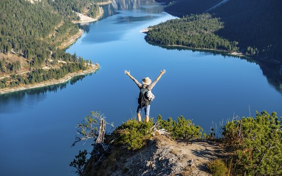 Hiker stretches out his arms in the air, view over the Plansee, Ammergau Alps, Reutte district, Tyrol, Austria