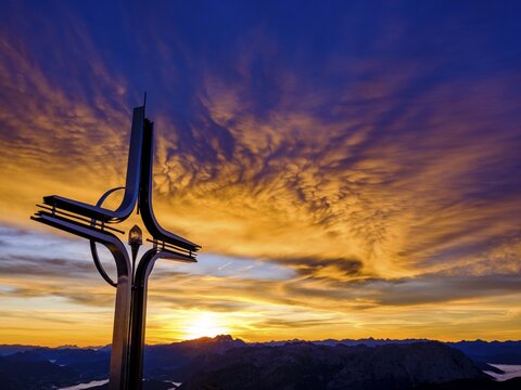 Colourful clouds at dawn, summit cross Hoher G&ouml;ll, Berchtesgaden Alps, Berchtesgaden National Park, Sch&ouml;nau am K&ouml;nigssee, Berchtesgadener Land, Upper Bavaria, Bavaria, Germany