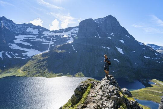 Hiker standing on a rock, view of mountain landscape and lake Giklingdalsvatnet, Flatvaddalen high valley, Innerdalen side valley, Sunndal, M&oslash;re og Romsdal, Vestlandet, Norway