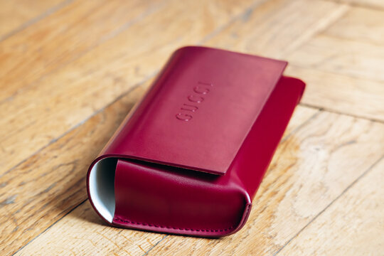 Nice, France - March 1, 2026: Red Gucci leather eyeglasses case photographed in a studio setting, featuring embossed Gucci branding, smooth leather finish and luxury accessory craftsmanship
