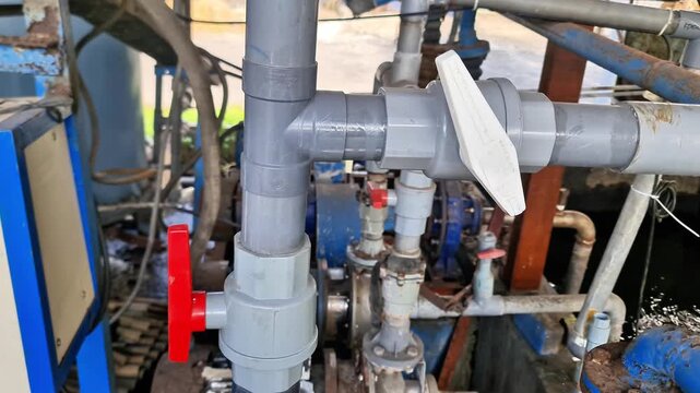 Outdoor Agricultural Irrigation System Featuring PVC Water Pipes, Red Valves, and Active Water Flow