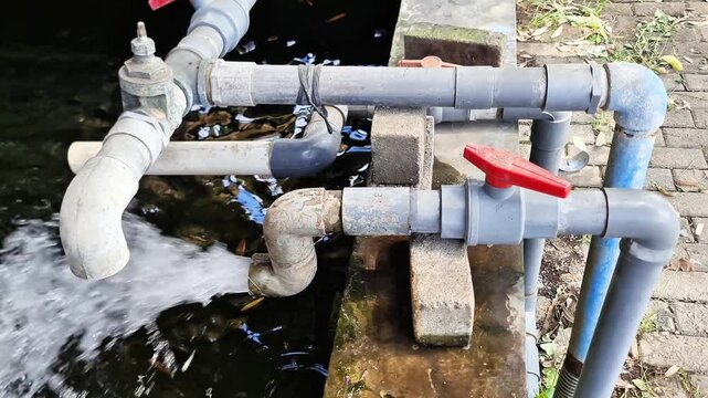 Sidoarjo, Indonesia - 13 June, 2026: Close Up Red Ball Valve on PVC Pipeline Controlling Water Flow in Industrial Outdoor System