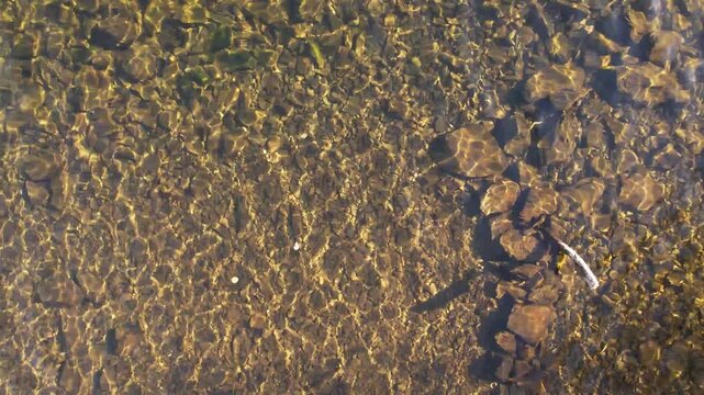 Aerial top-down drone view of clear lake shallows with minimal movement, Lake District in England