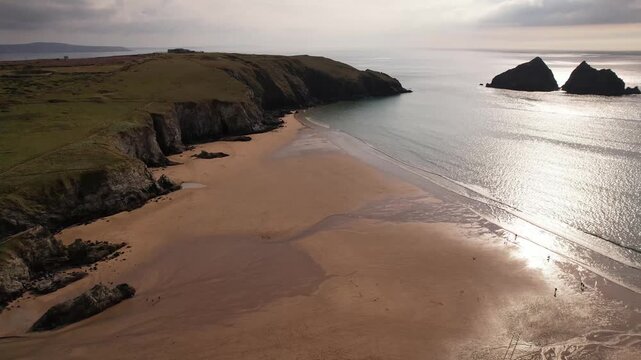 Aerial drone panorama over Holywell Beach, Cornwall in summer, England at golden hour