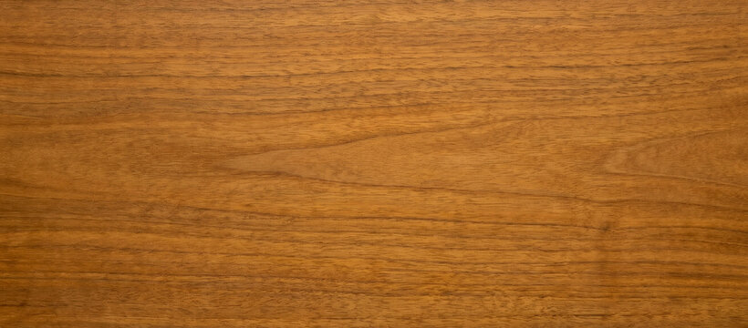 A close-up view of a smooth, polished wooden surface showcasing rich, warm tones and a natural wood grain pattern, ideal for backgrounds and textures.