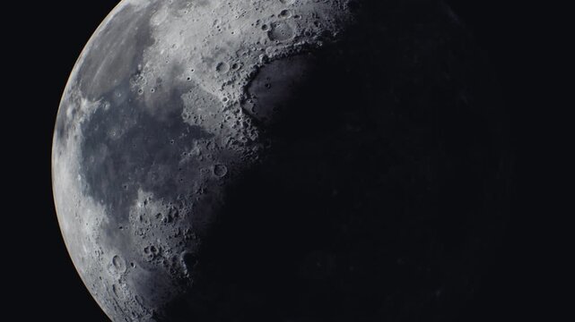 The moon displays intricate craters and rugged terrain under a contrasting light. The surface textures are highlighted, showcasing the lunar landscape.
