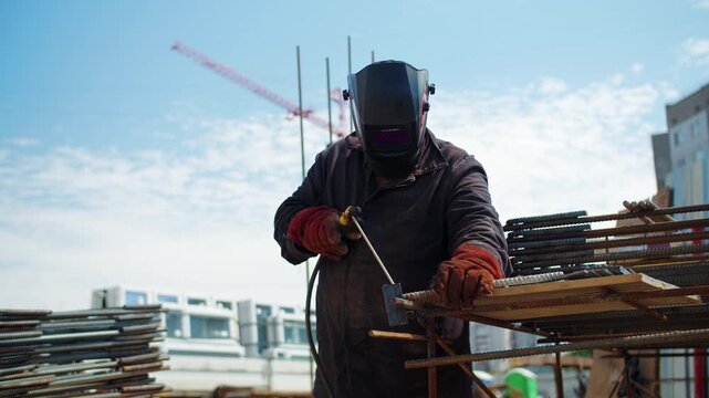 Construction worker welding steel reinforcement bars