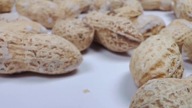 Raw Inshell Peanuts Camera Panning Right to Left Close-up, Heap of Groundnuts in Shells on White Surface, 16:9 Landscape Traditional Snacks Stock Footage