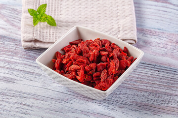 Dried goji berries in white bowl with mint leaf © Andrei Starostin