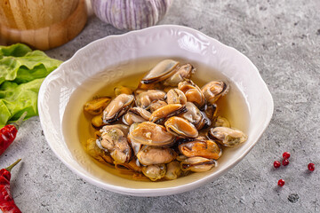 Fototapeta premium Pickled Mussels in Oil with Herbs and Spices on Concrete Background