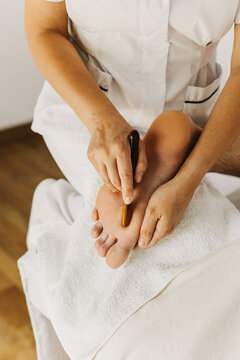 Close up of special foot massage therapy session. Female massage therapist's hands.