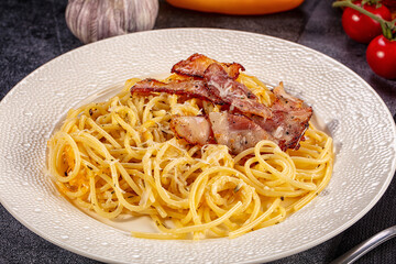 Fototapeta premium Spaghetti carbonara with crispy bacon and cheese on white plate