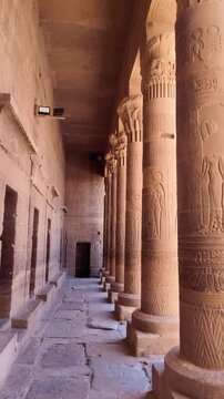 POV of Magnificent columns carved with ancient egyptian hieroglyphs inside the philae temple in aswan, egypt. Historic corridor of a famous landmark