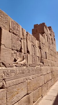 Detailed hieroglyphic carvings and bas reliefs on a sandstone wall at the ancient philae temple in aswan, egypt