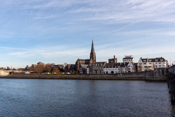 Fototapeta premium Historic skyline of Maastricht featuring St Martins Church spire across the Meuse river