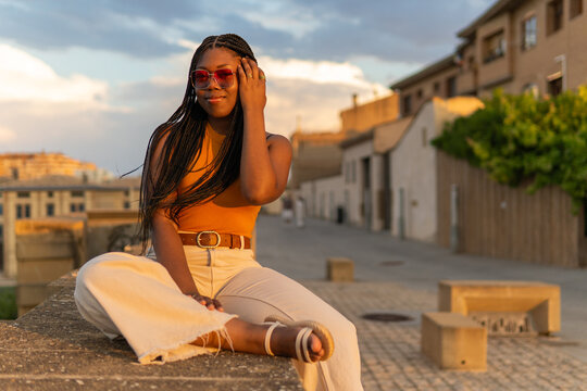 Young woman sitting outdoors at golden hour