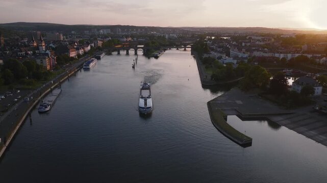 Barge floats by Moselle River in Coblenz. Sunset at Mosel in Koblenz, Mosel river joins Rhine in Germany. Aerial shot