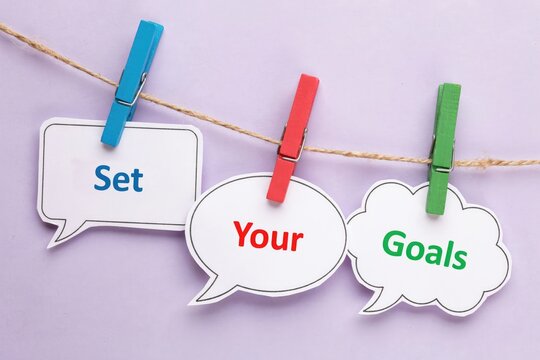 Set your goals text on speech bubbles hanging from a string with clothespins