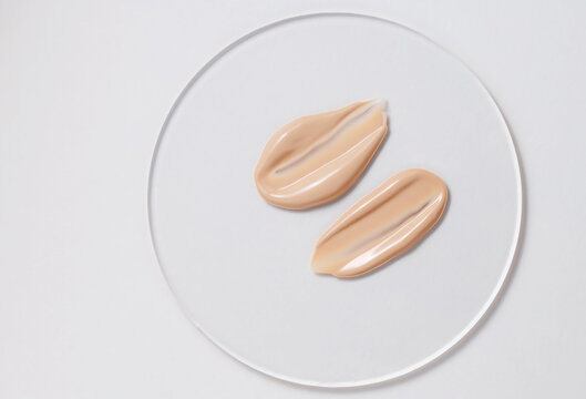 Close-up of two beige foundation samples on a white background.