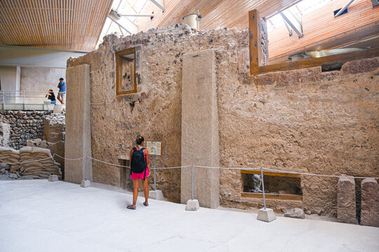 Woman exploring ancient Akrotiri Minoan archeological site in Santorini