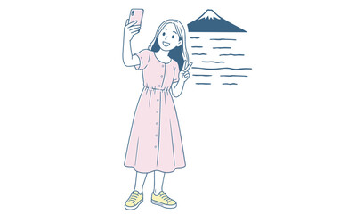 Fototapeta premium 富士山を背景に自撮りする女性 A woman taking a selfie with Mount Fuji in the background.