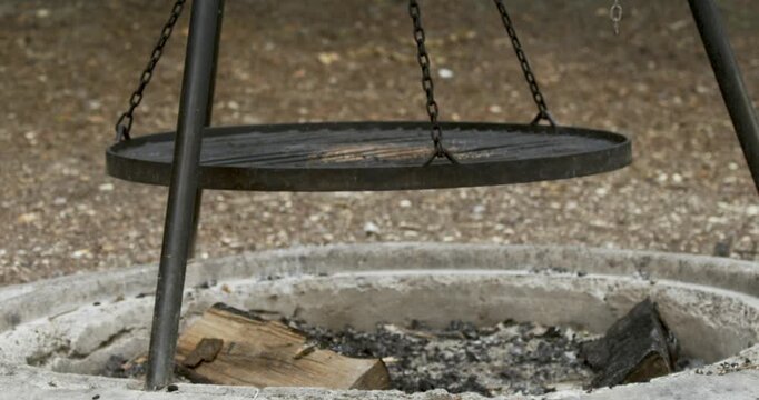 Suspended Metal Grill Over Rustic Outdoor Fire Pit