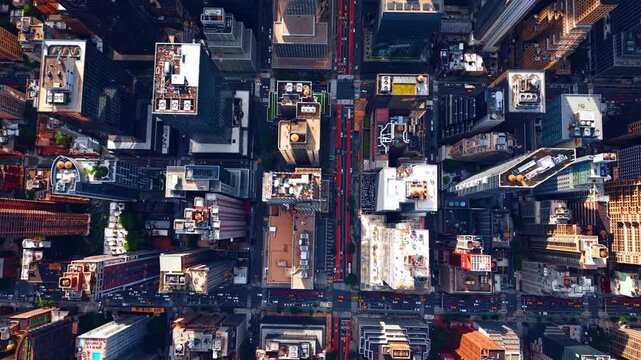 Straight down top view of midtown Manhattan streets and building rooftops. Complete nadir aerial perspective of New York City street grid with traffic, red bus lanes and skyscraper roofs.