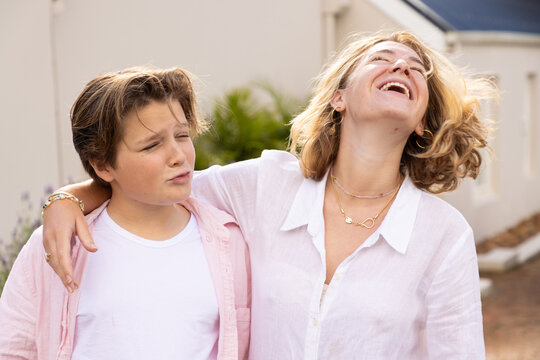 pre teen and young woman siblings smiling and embracing