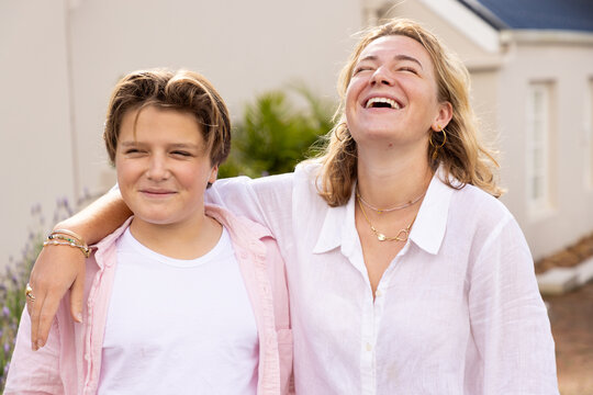 pre teen and young woman siblings smiling and embracing
