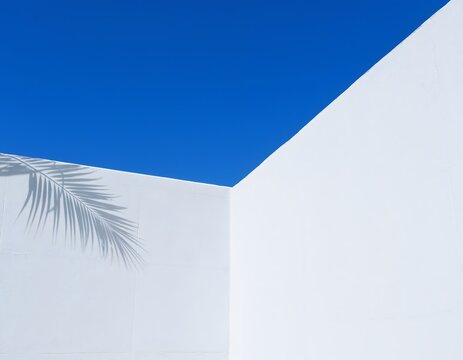 Minimalist architecture shot featuring a stark white concrete wall meeting a deep blue sky with sharp geometric angles dynamic shadows and clean abstract structural lines