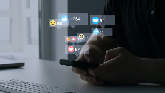 Man using smart phone with emoticon icons of Social Media.Interactive with friends on chat with emoticon feedback.Social media,marketing, like,social network,blog,live,chat reaction and livestream.	
