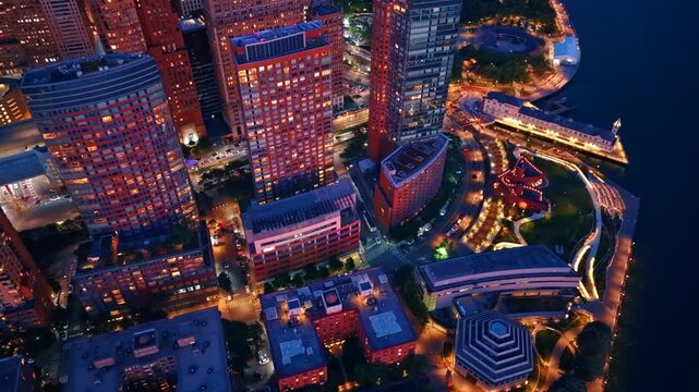 Top down aerial view of Battery Park City streets at night. Vertical high angle view of illuminated residential buildings and streets in Battery Park City at twilight.