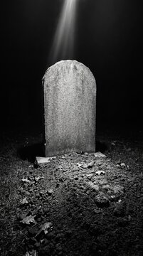 Somber grave marker cemetery black and white photography nighttime ground level reflection on life