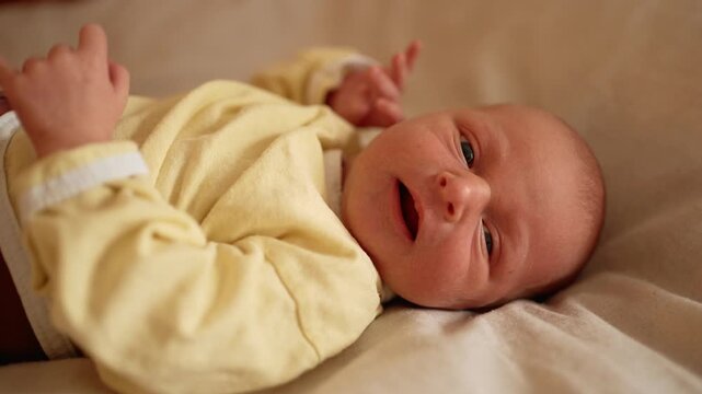 Close up of a newborn infant lying down, showing various facial expressions from crying with an open mouth to making funny grimaces, capturing the emotional journey of a baby