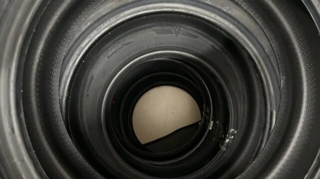 Stacked summer tires top view showing concentric inner wells and speckled rubber texture, close-up overhead shot of new passenger