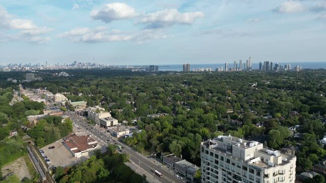Aerial over Bloor Street West from Islington, heading to the Kingsway of Toronto, Ontario, Canada. Flying southeast with the downtown core Toronto skyline, Mimico and Lake Ontario in the distance.