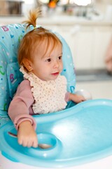 Fototapeta premium Toddler girl learning self feeding