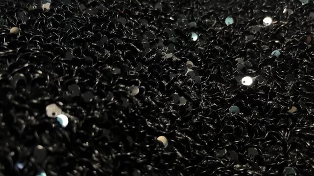 Shimmering Black Sequins Close Up in Motion. Luxury Glitter Texture with Black Sequins. Glamorous Black Sequin Background with Sparkle Effect. 