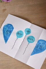 Obraz premium Top view of a Father's Day greeting card with the message “Best Dad Ever” placed on a clean background. Minimal holiday composition celebrating fatherhood and family appreciation.