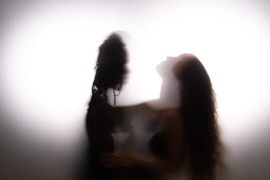 Sensual couple dancing and hugging together behind frosted glass