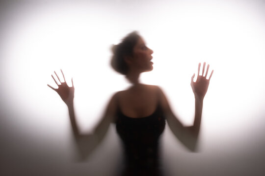 Woman trapped in frosted glass space seeking for an escape