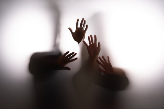 People touching frost glass together against white background. Seeking for an escape from emotional confinement concept