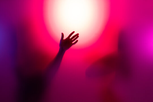 People silhouettes behind frosted glass. Closeup of hand