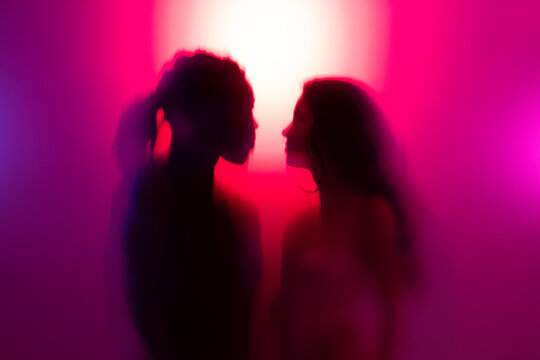Multiracial young couple together behind frosted glass