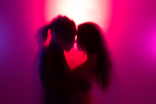 Romantic couple hugging behind frost glass