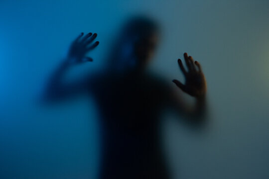Black American man posing at studio behind frost glass displaying anonymity and privacy concept 